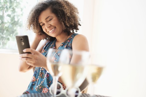 Young woman using smart phone at restaurant.