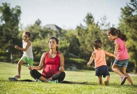 Pregnant mother and children (2-3, 6-7, 8-9) in park
