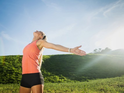 Woman with outstretched arms in field