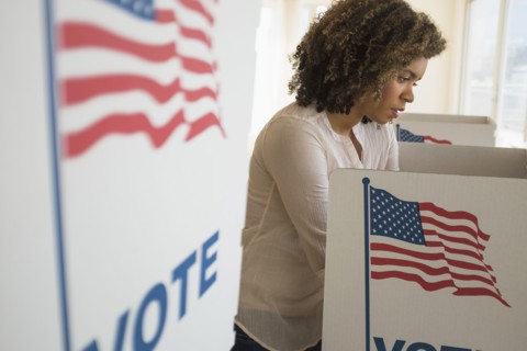 Young woman preparing voting booth.