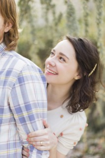 Young woman hiding behind boyfriend