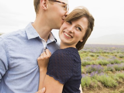 Young couple embracing with field on background