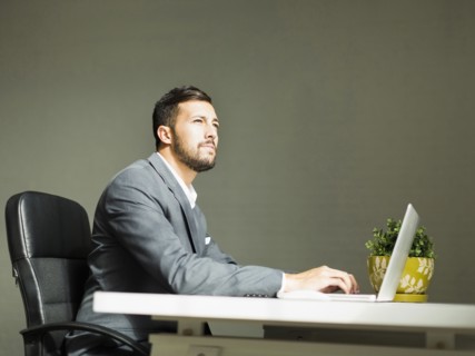 Young man sitting at desk and using laptop