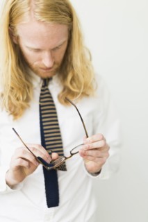 Blond man wiping glasses