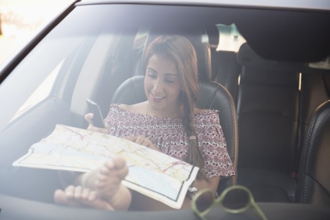 woman sitting in car and looking at map.