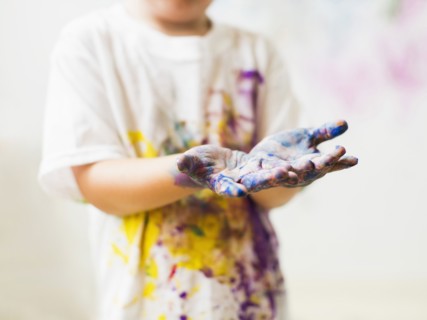 Boy (2-3) showing hands in paint