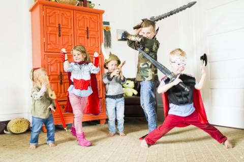 Children (2-3, 4-5, 6-7) wearing superhero costumes playing at home