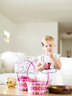 Girl (2-3) eating candy in living room