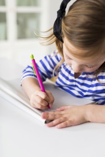 Girl (4-5) drawing in living room