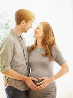 Mid-adult couple face to face outdoors.