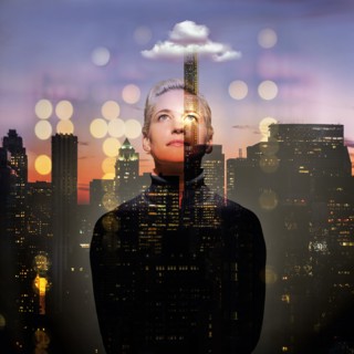 Young woman looking up at night. USA, New York, New York City.