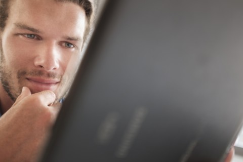 Mid-adult man using tablet pc.