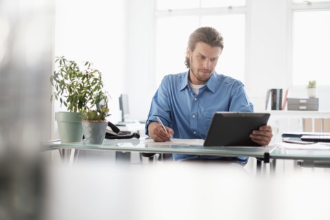 Mid-adult businessman working in office.