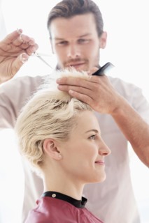 Hairdresser cutting woman's hair.