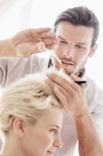 Hairdresser cutting woman's hair.