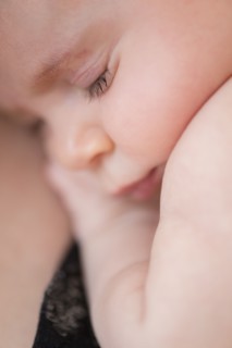 Close-up of baby girl (2-5 months) hugging her mother