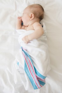 Baby girl (2-5 months) sleeping on bed