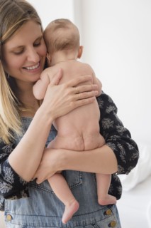 Woman holding baby girl (2-5 months) in her arms