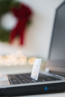 Laptop with credit card and Christmas decoration in background