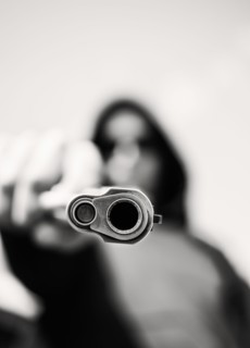 Man with handgun pointing towards camera