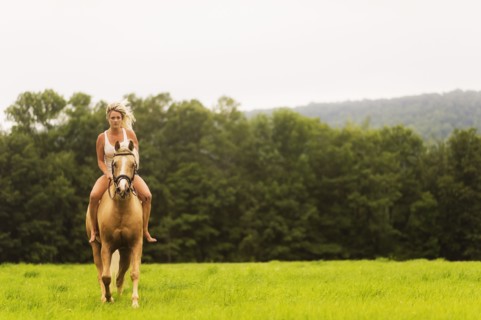 Woman horseback riding in countryside