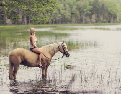 Woman horseback riding in countryside