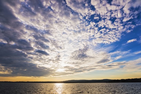 Cloudy sky above bay at sunset