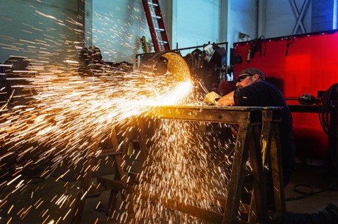 Welder working in metal workshop