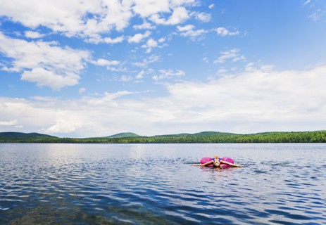 Young woman relaxing on lake in pool raft