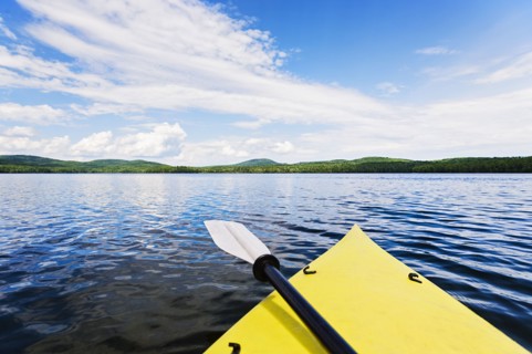 Bow of yellow kayak on lake