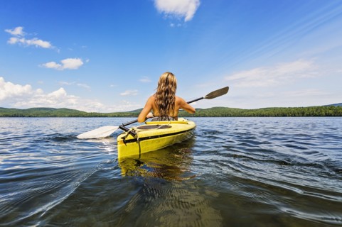 Young woman kayaking on lake