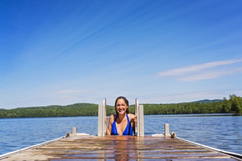 Young woman coming out of water on jetty