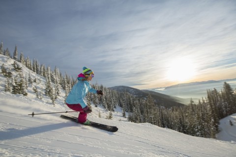 Mature woman on ski slope at sunset