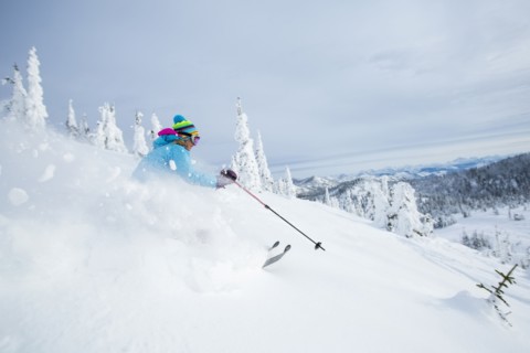 Mature woman speeding on ski slope