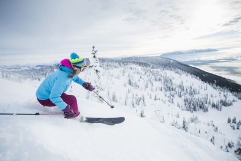 Mature woman speeding on ski slope