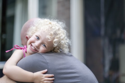 Smiley daughter (4-5) hugging father