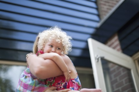 Smiley daughter (4-5) hugging mother