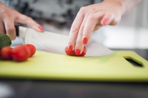 Woman cutting tomatoes on cutting board