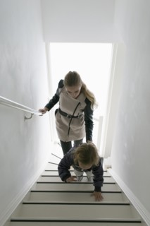 Mother and son (4-5) walking up stairs