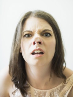 Woman making funny face on glass