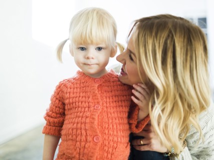 Cute girl (2-3) looking at camera with mother