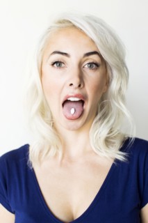 Studio shot of woman taking pill