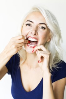 Studio shot of woman using dental floss