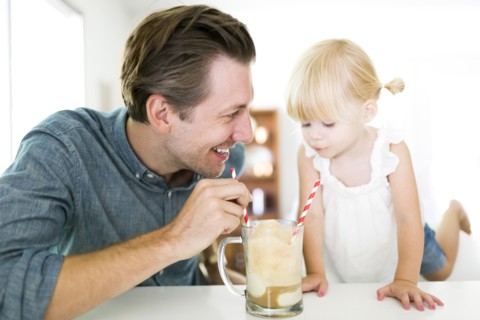 Father drinking milkshake with daughter (2-3)