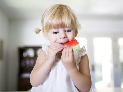 Portrait of girl (2-3) eating watermelon