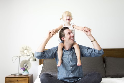 Portrait of father carrying daughter (2-3) on shoulders