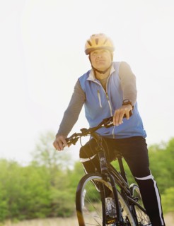 Mature man riding bicycle.
