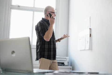 Man in office using smartphone.