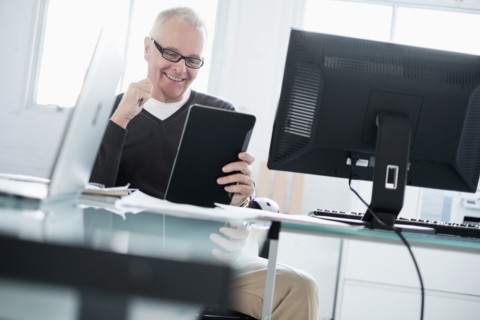 Man in office using tablet.