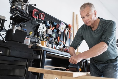 Man working with wood in home workshop.